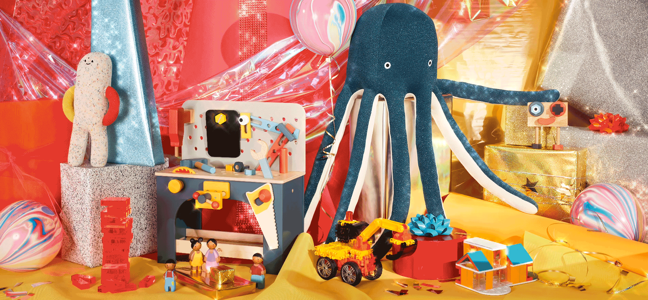 Holiday still life image of a plush octopus, a toy workbench, a toy tractor and red blocks