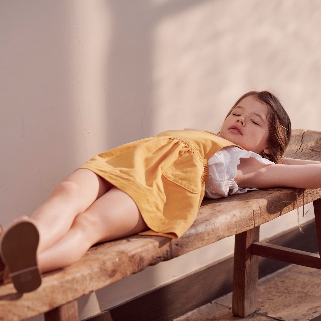 girl laying on a bench