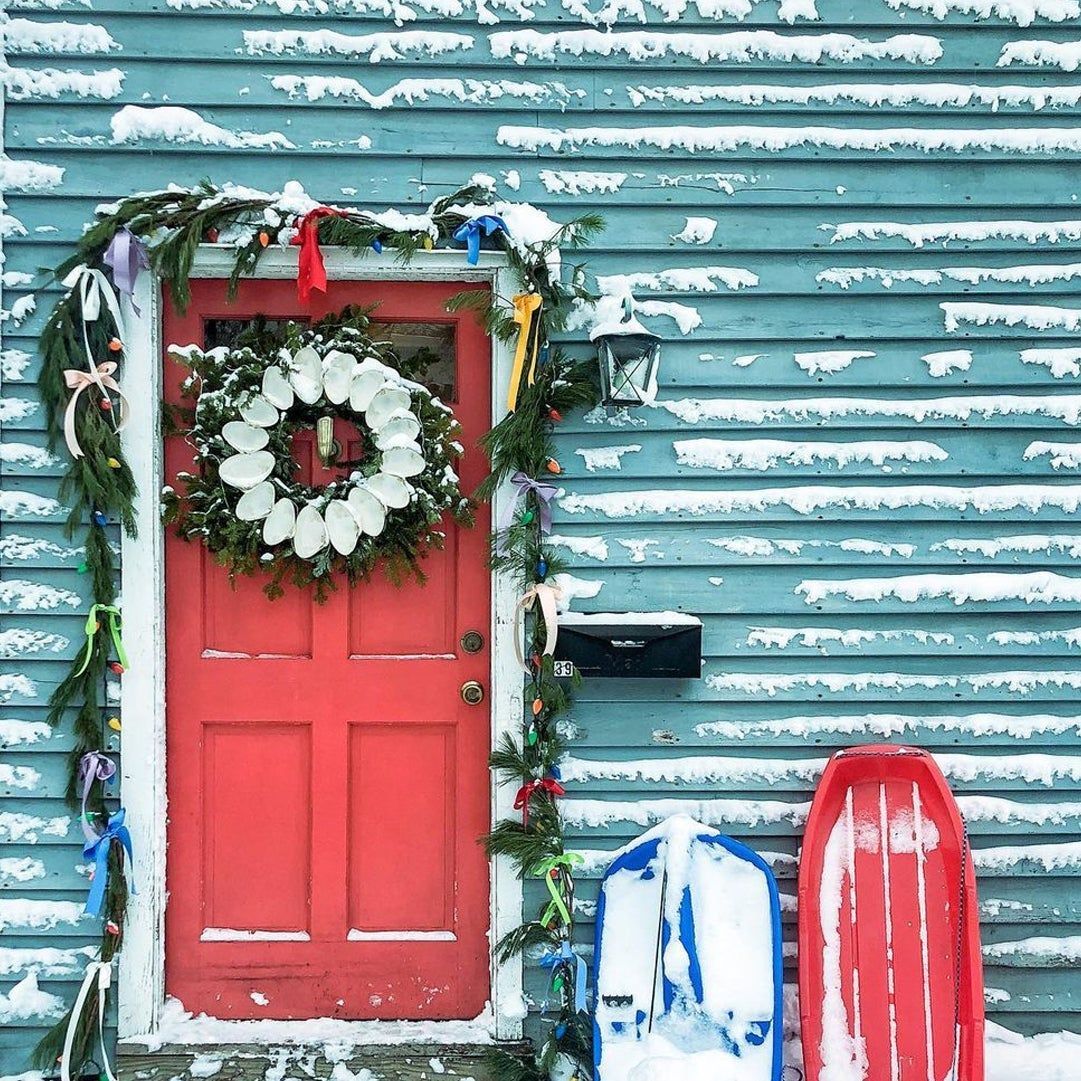 evergreen garland around a front door tied with bows