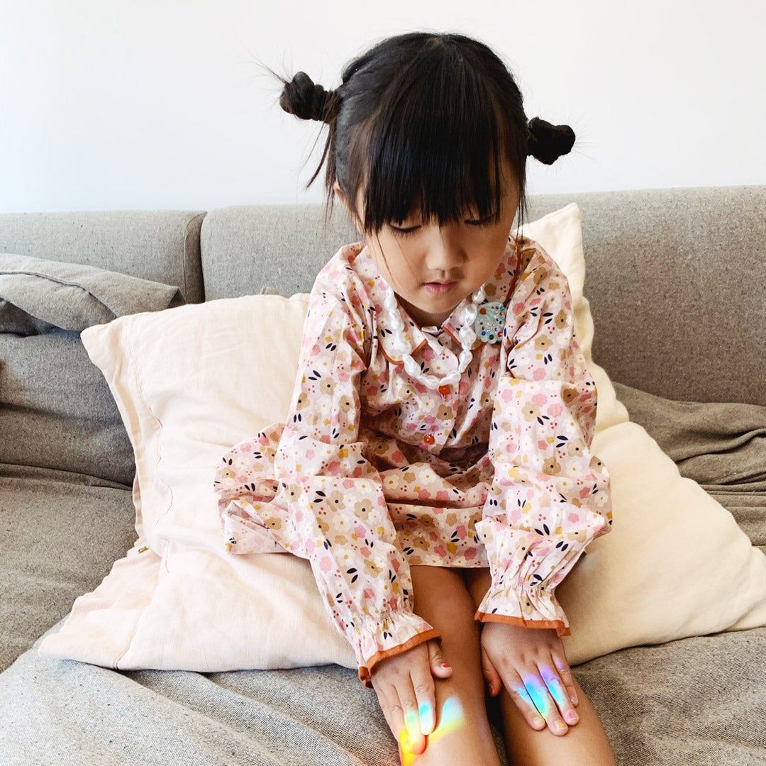 girl playing with rainbow prism on the couch
