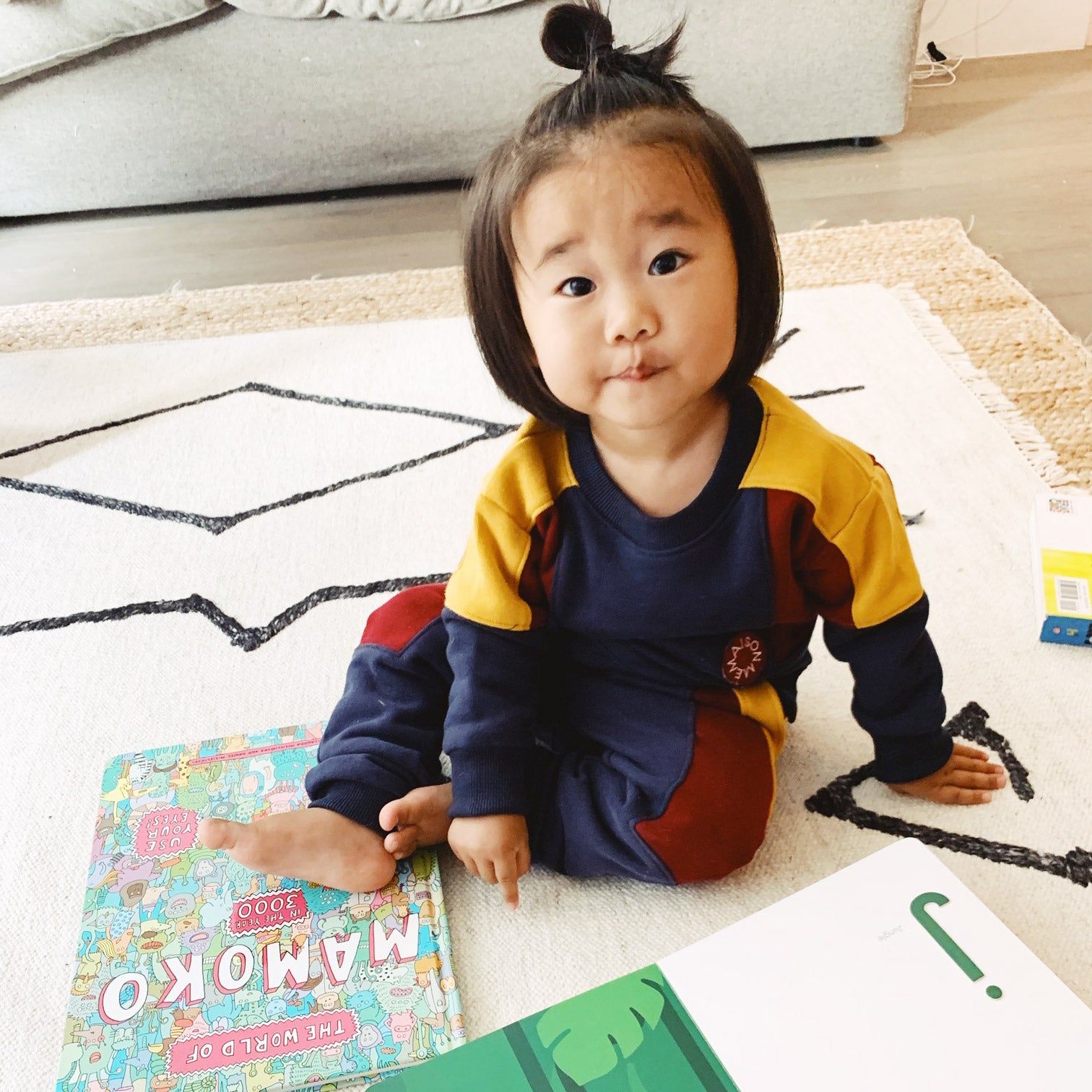 child reading books on the floor