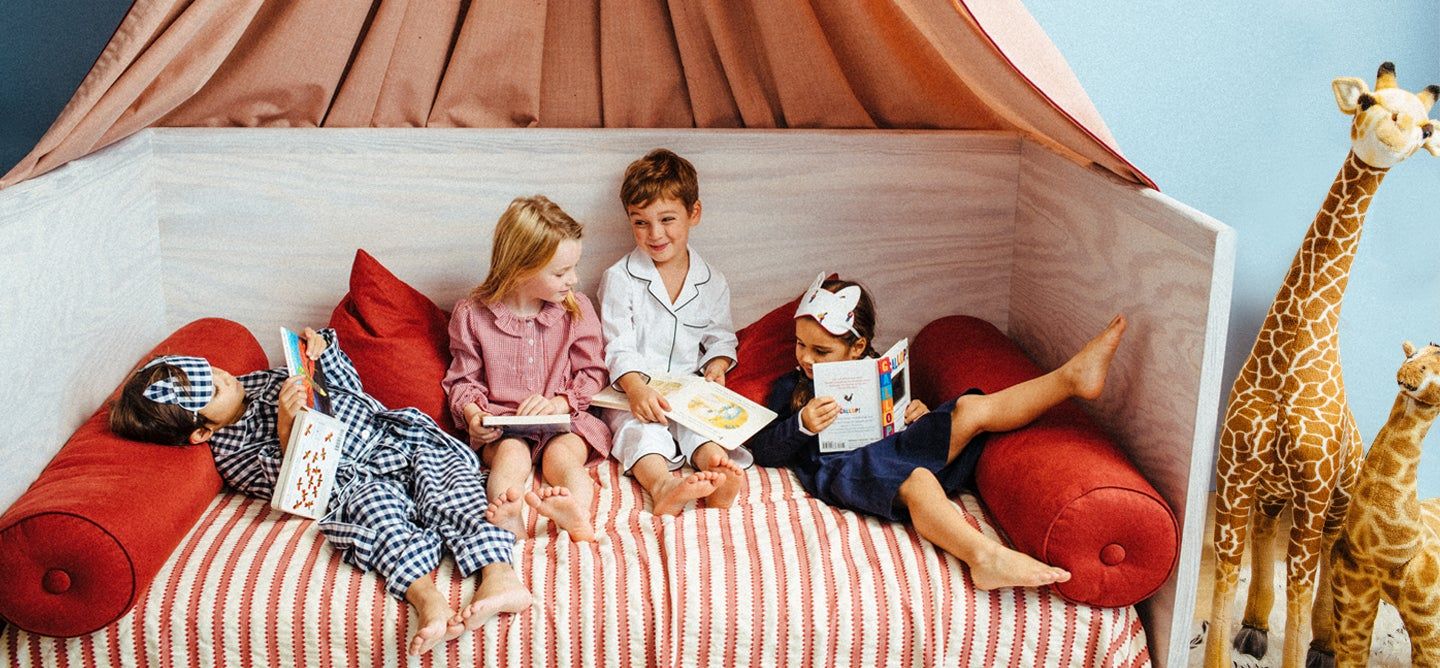 kids on a bed reading books