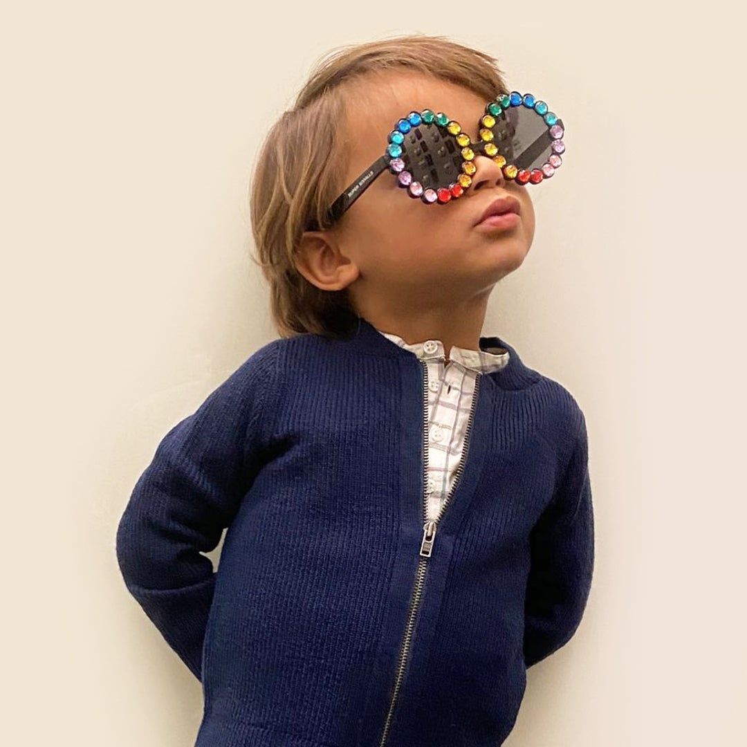 A little boy with rainbow colored sunglasses