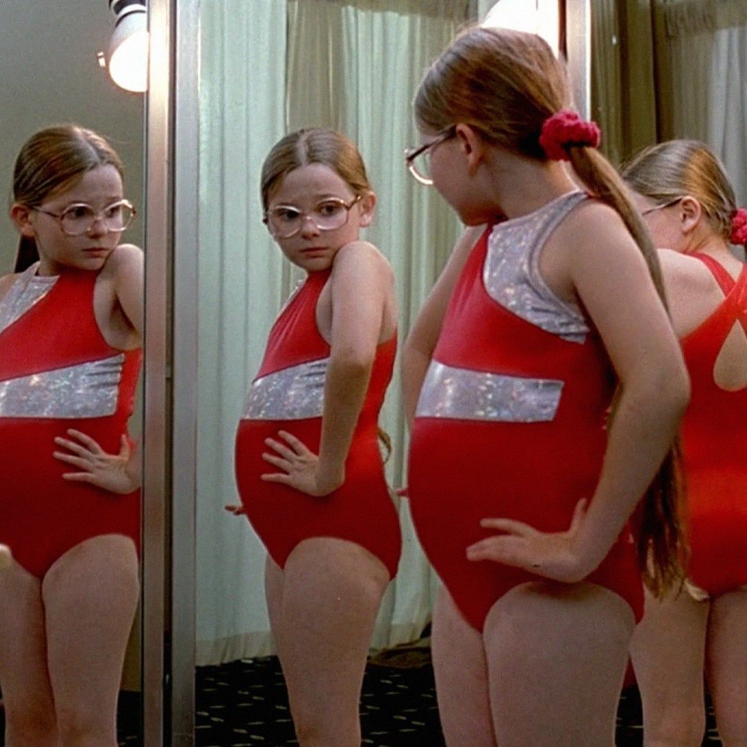 Olive from Little Miss Sunshine looking at herself in the mirror