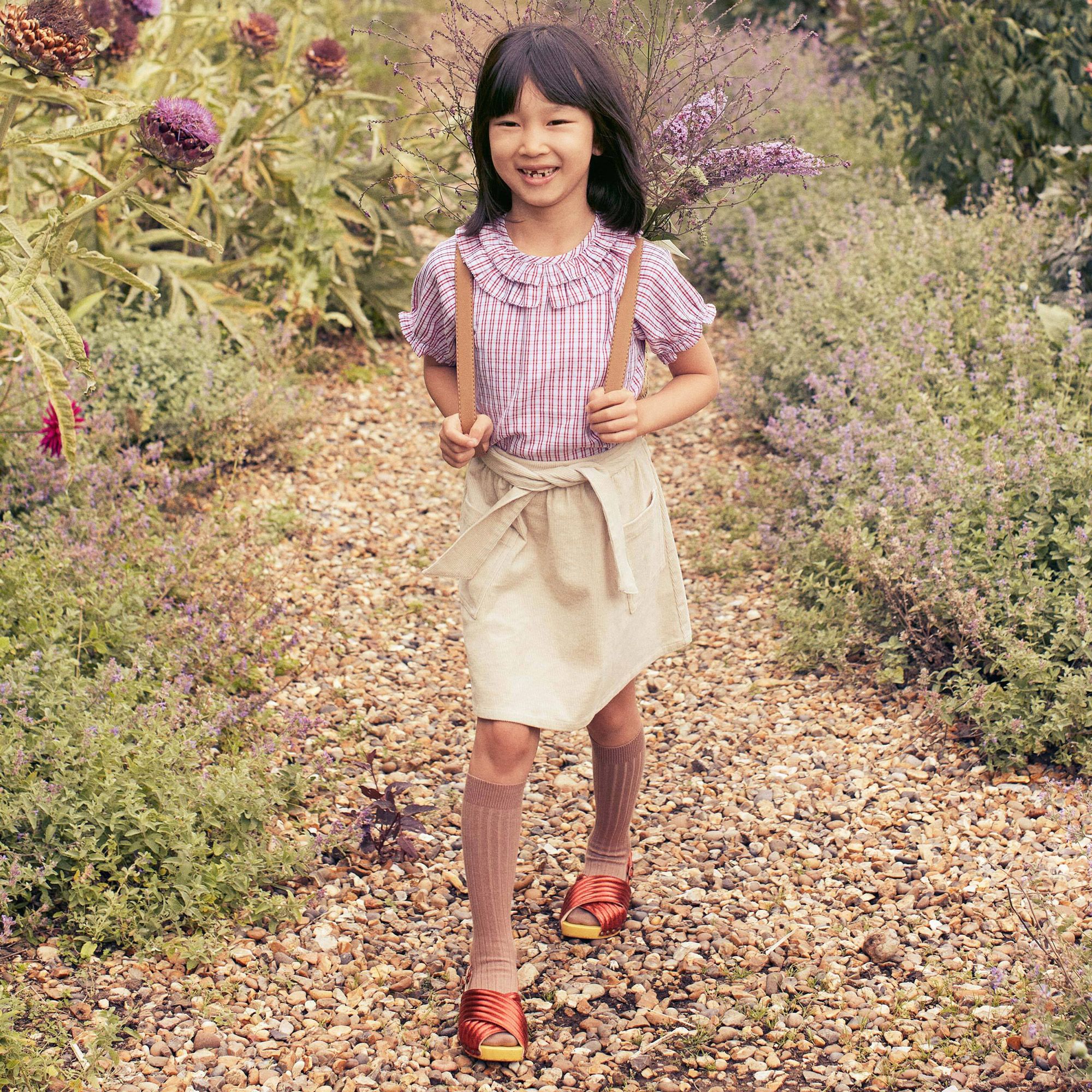 Girl wearing Brynn Top in a garden