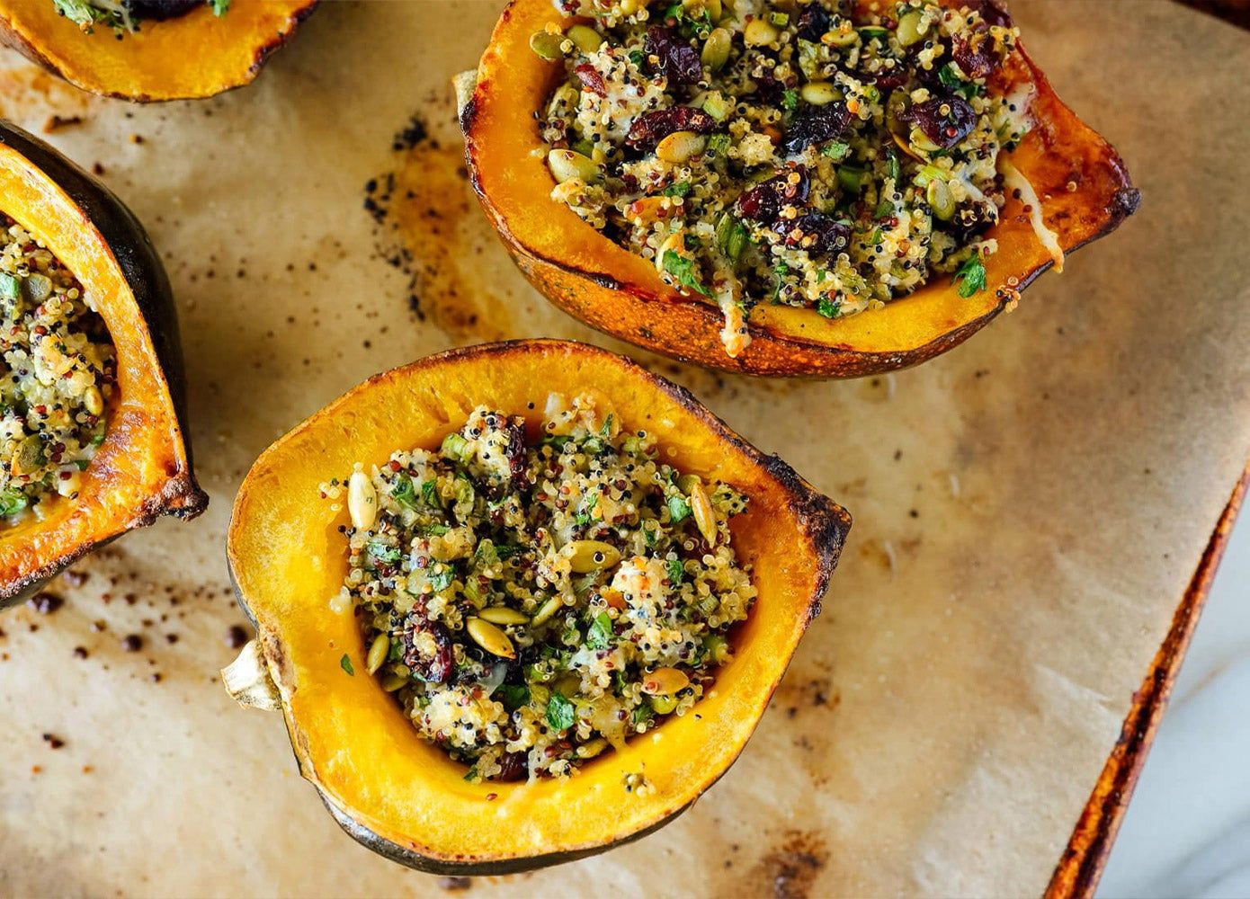 A sheet of acorn squash stuffed with quinoa, cranberries, and pipits