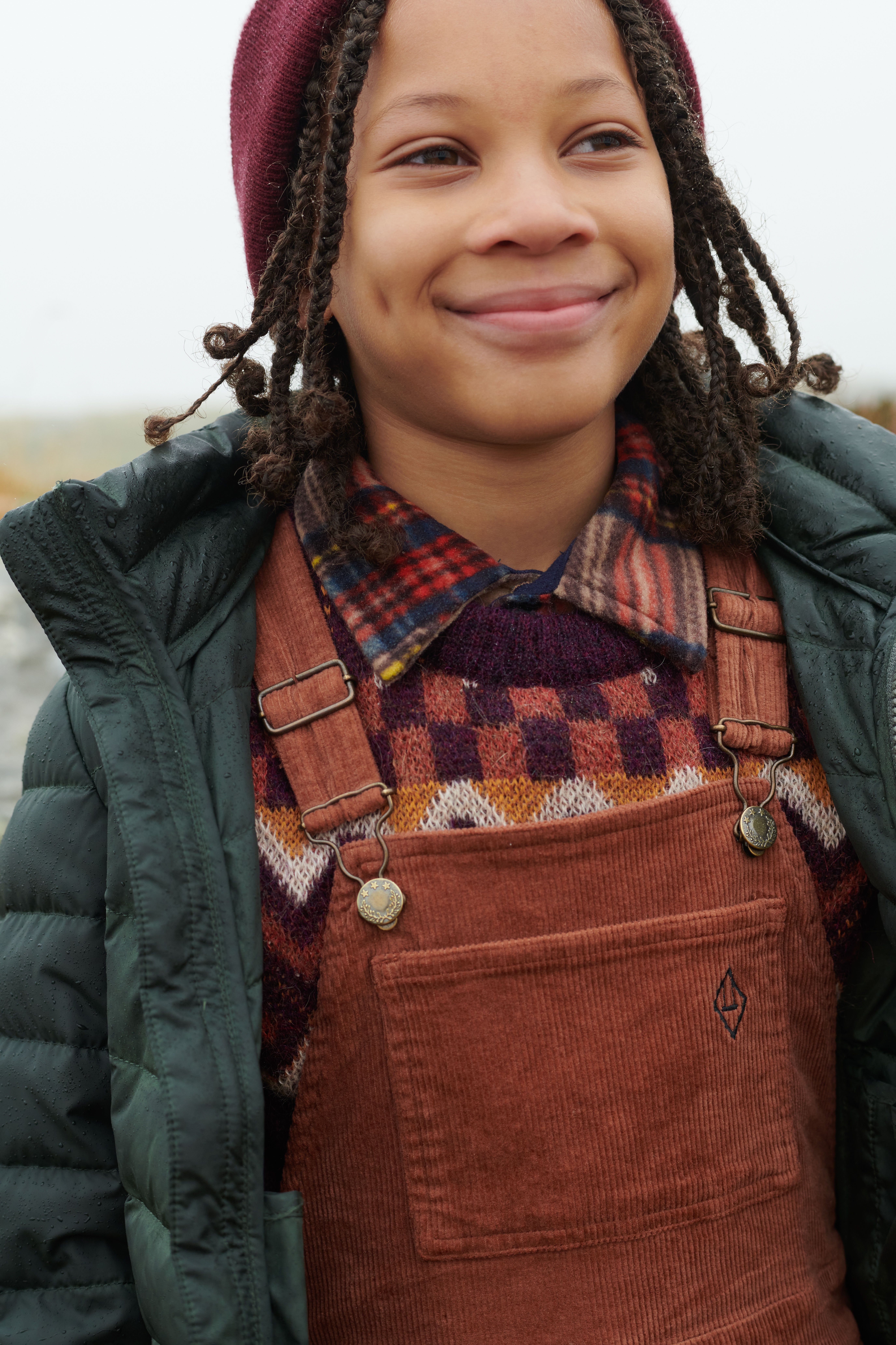 photo of a boy outside with overalls and winter gear