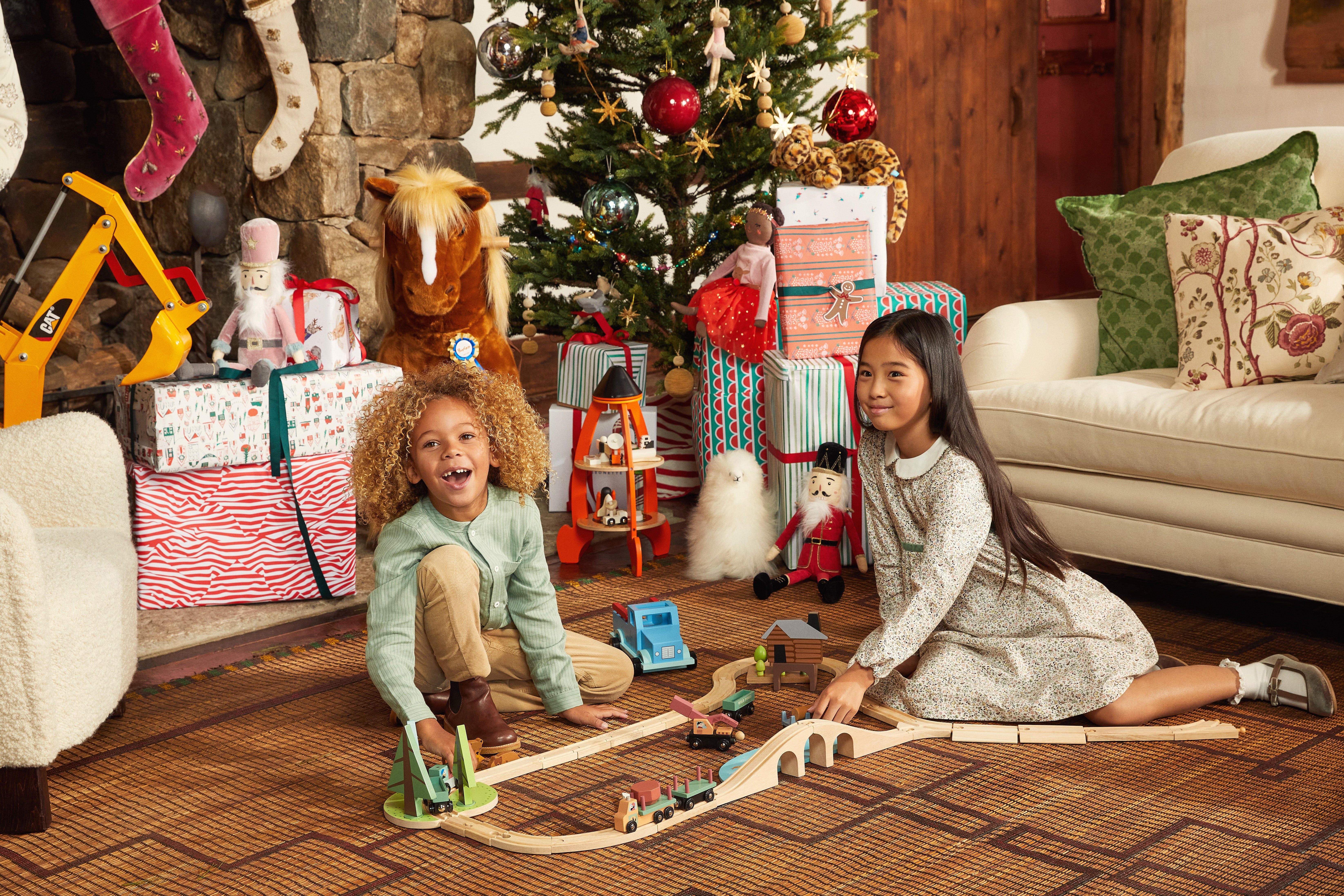 two kids in front of a Christmas tree