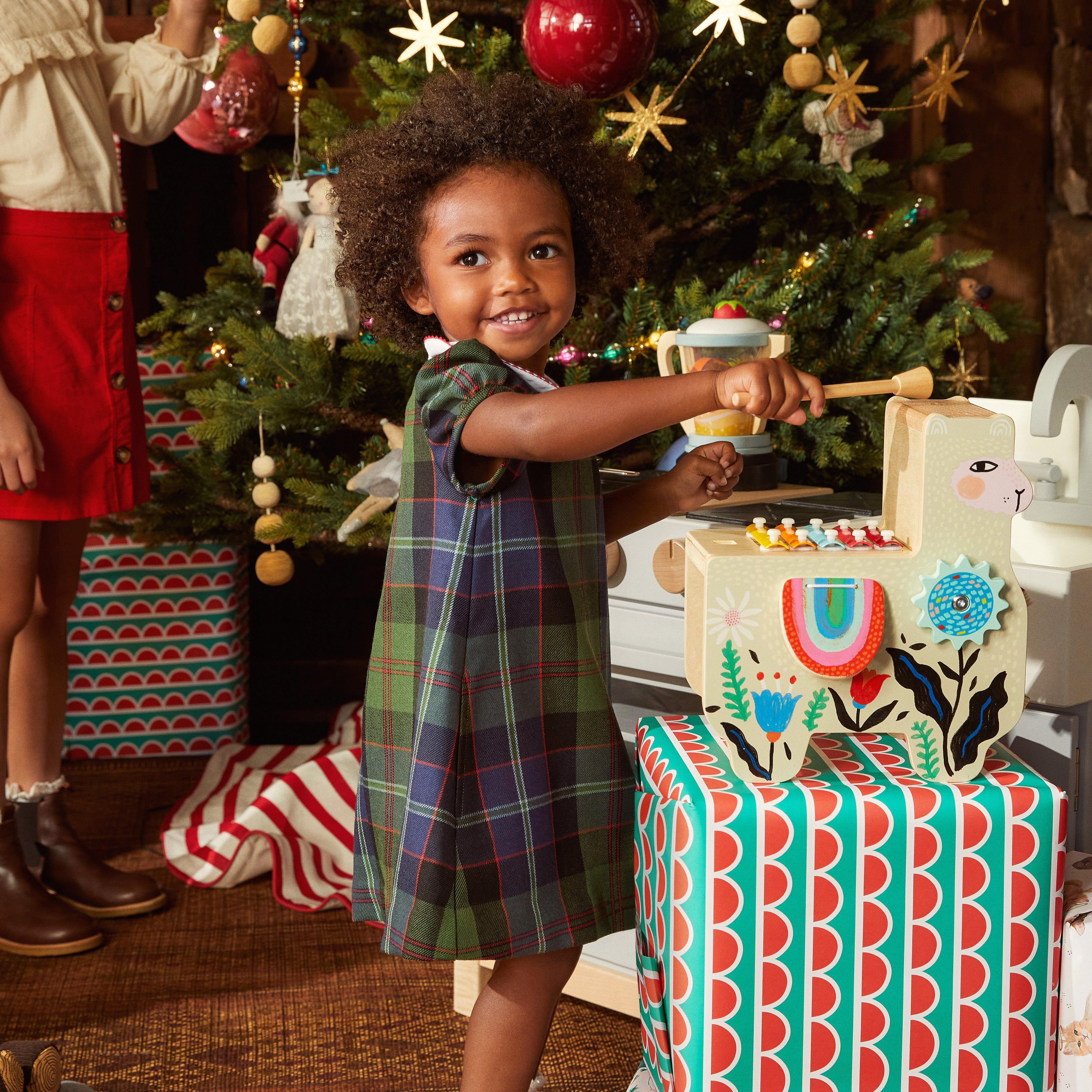 baby in tartan Christmas tree and presents