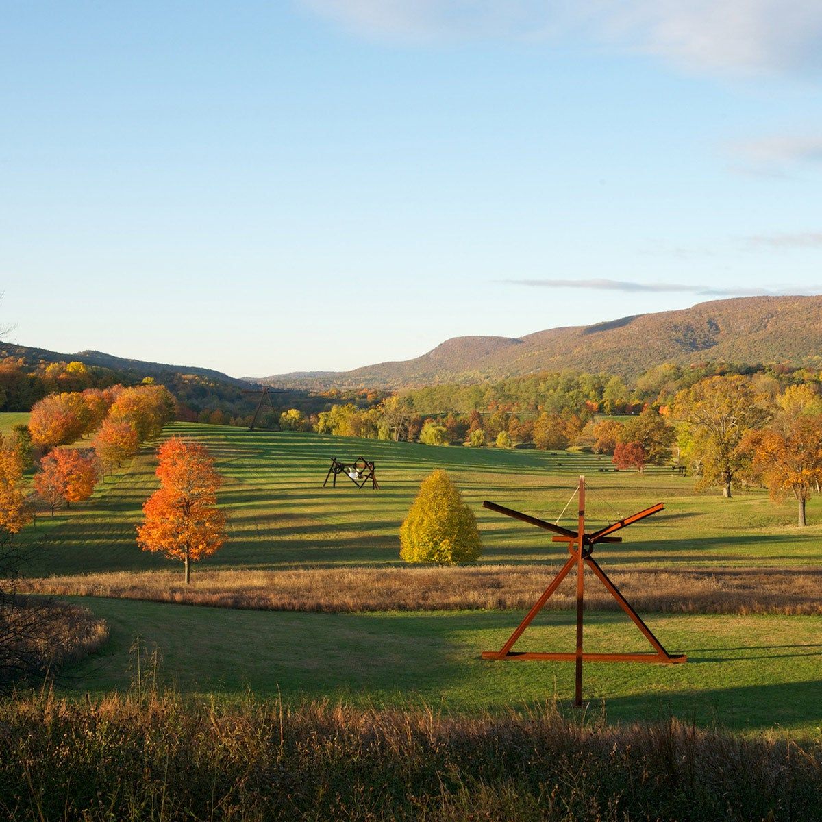 Storm King Art Center in the fall; depicted are sculptures created by Mark di Suvero in a large valley.
