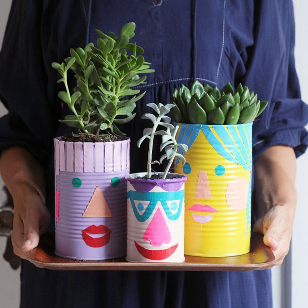 Three planters with colorful faces painted on them