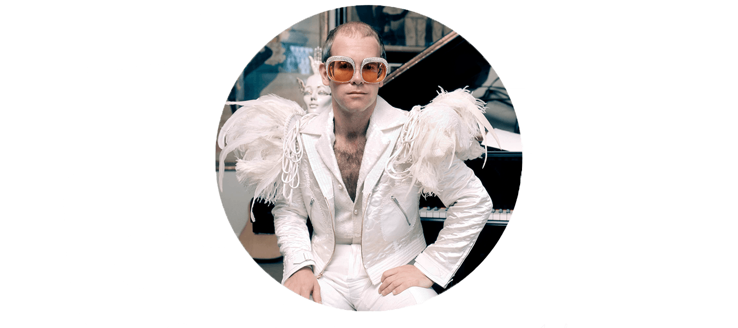 Elton John in white suit at a piano