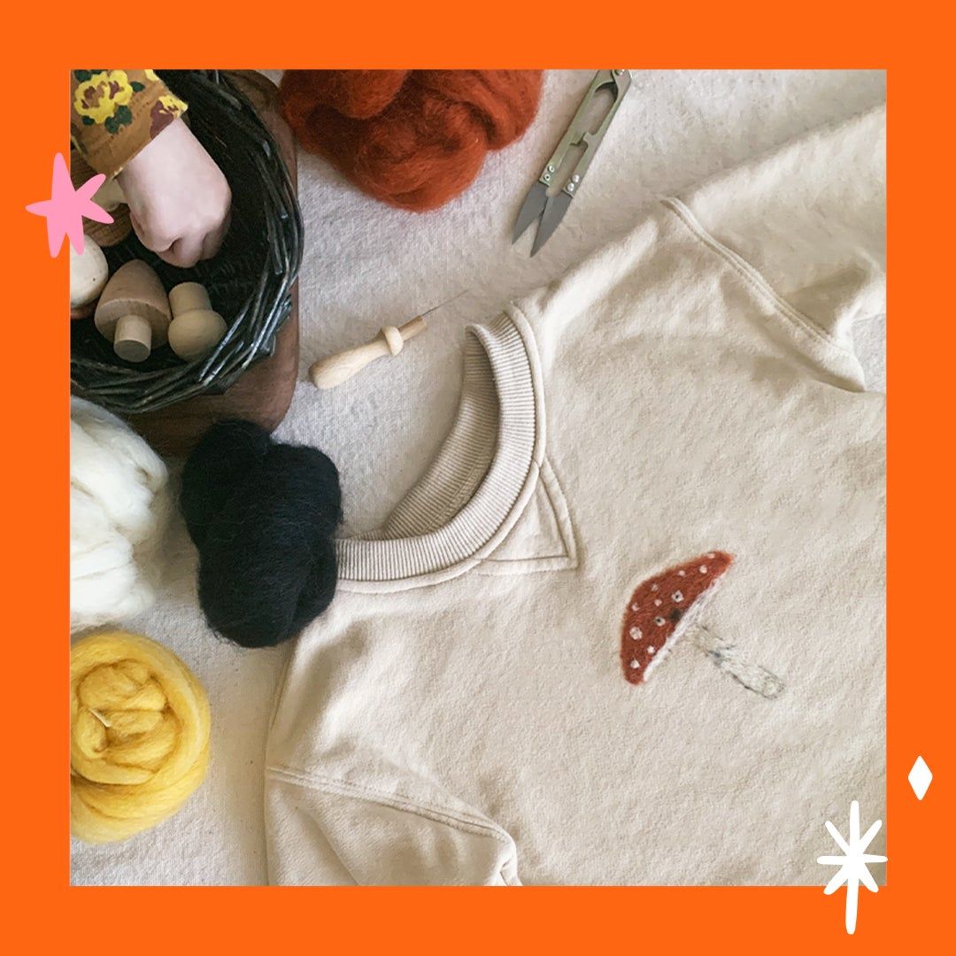 a white sweatshirt with a mushroom felt applique
