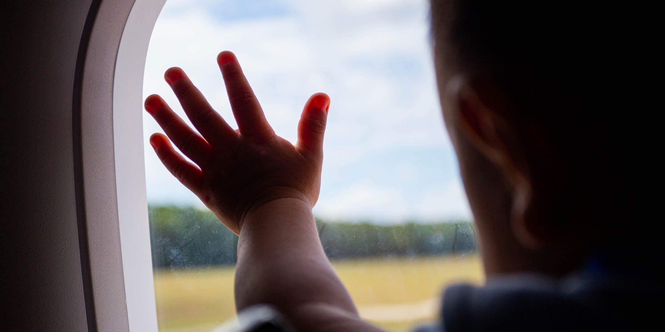 baby with hand on a plane window