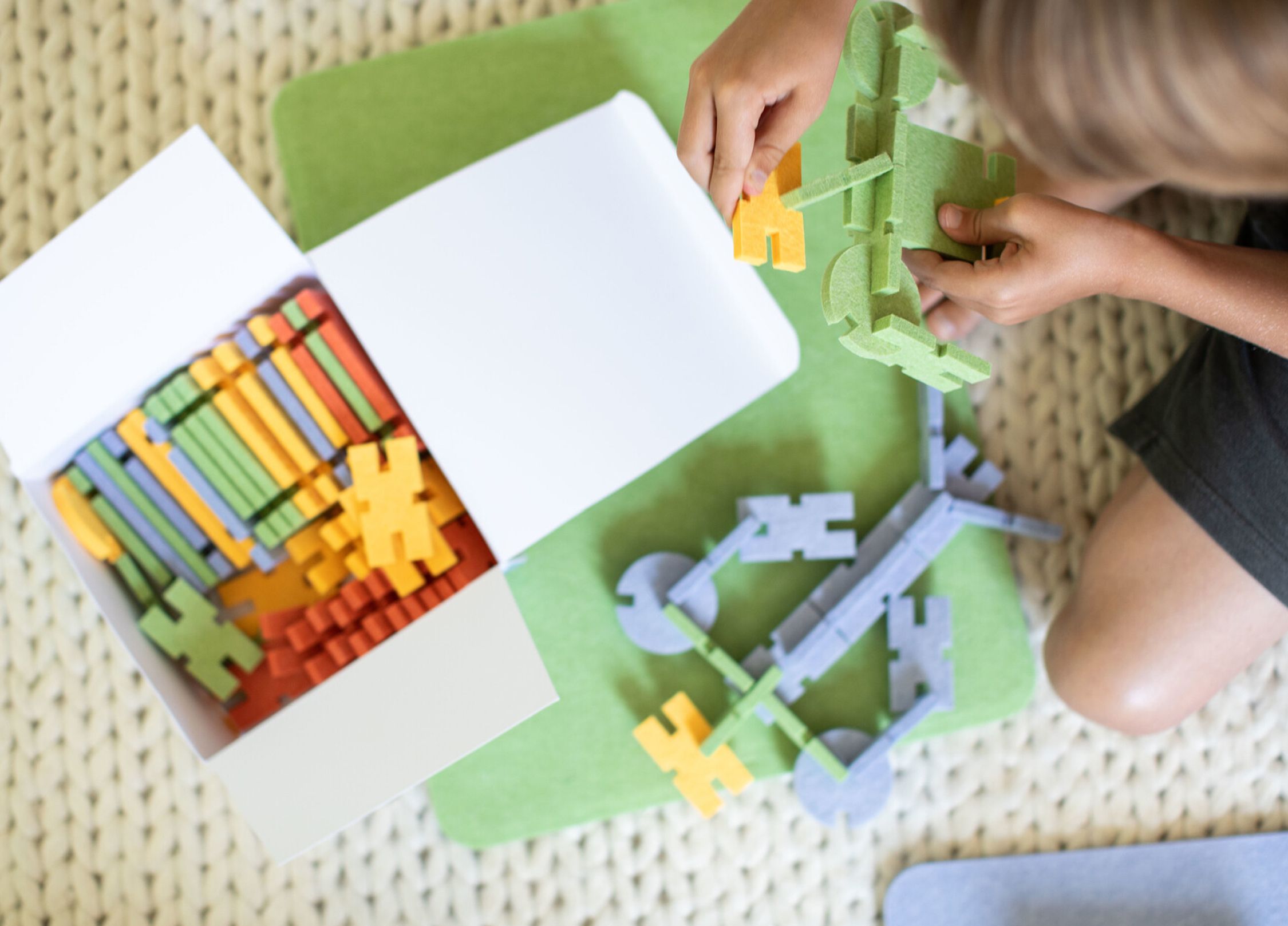A young boy plays with open-ended building toys during free time.