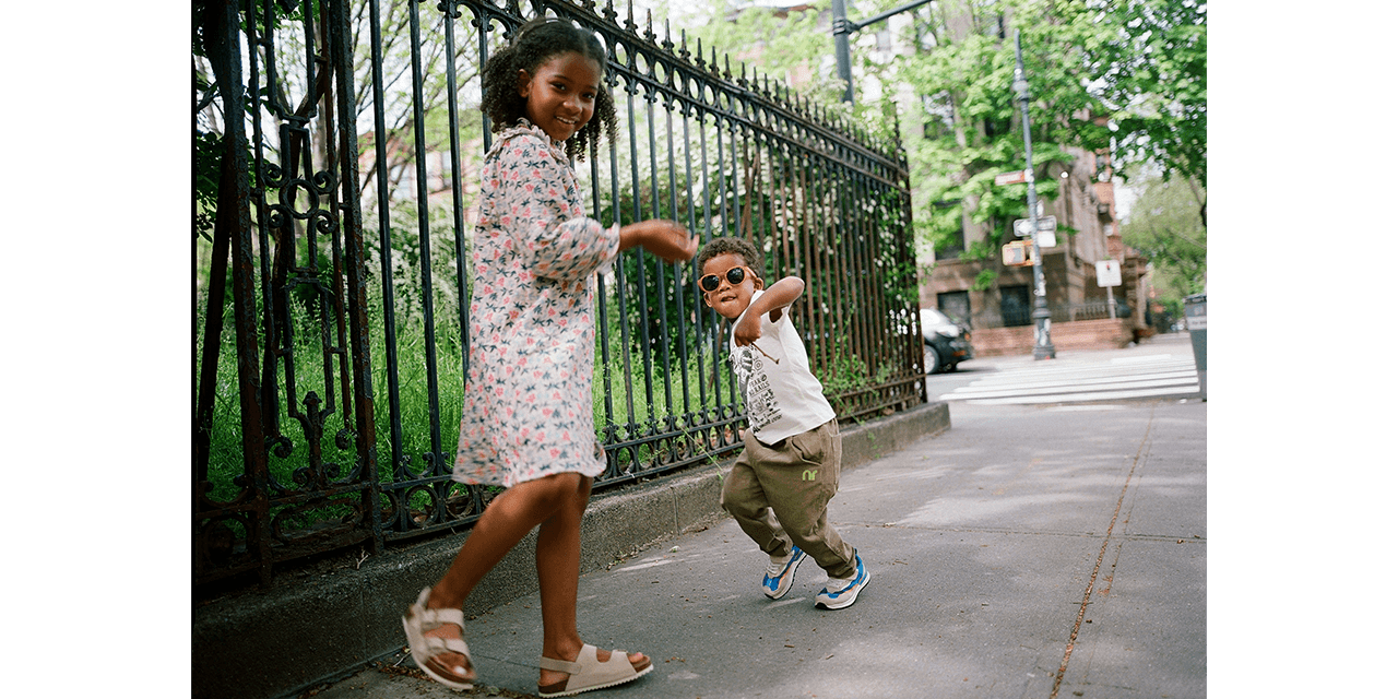 brother and sister walking on the sidewalk in the spring