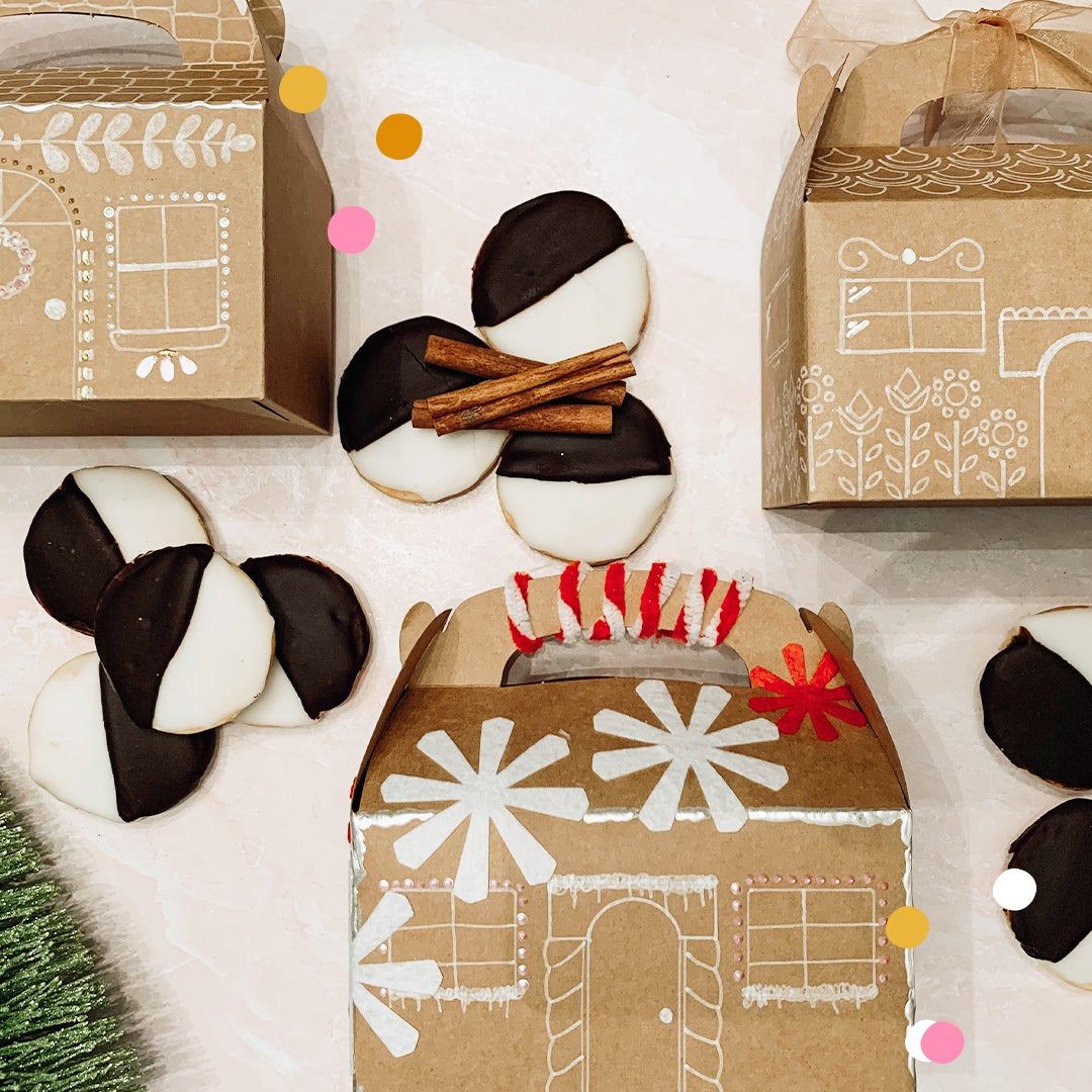Cardboard gingerbread boxes and black and white cookies with cinnamon sticks