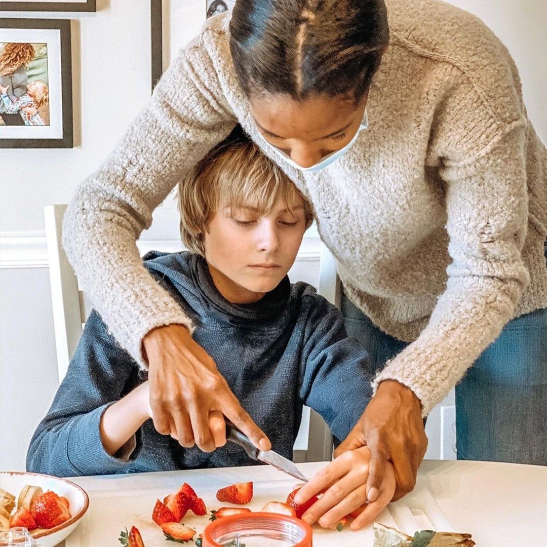 Gabe with his aides posing and smiling (left) and cutting strawberries (right)