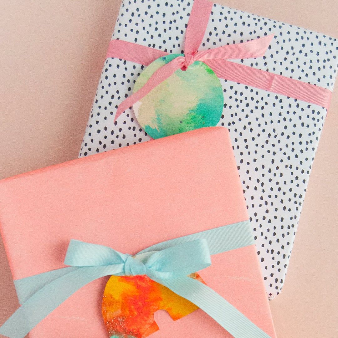 two wrapped packages with colorful painted gift tags