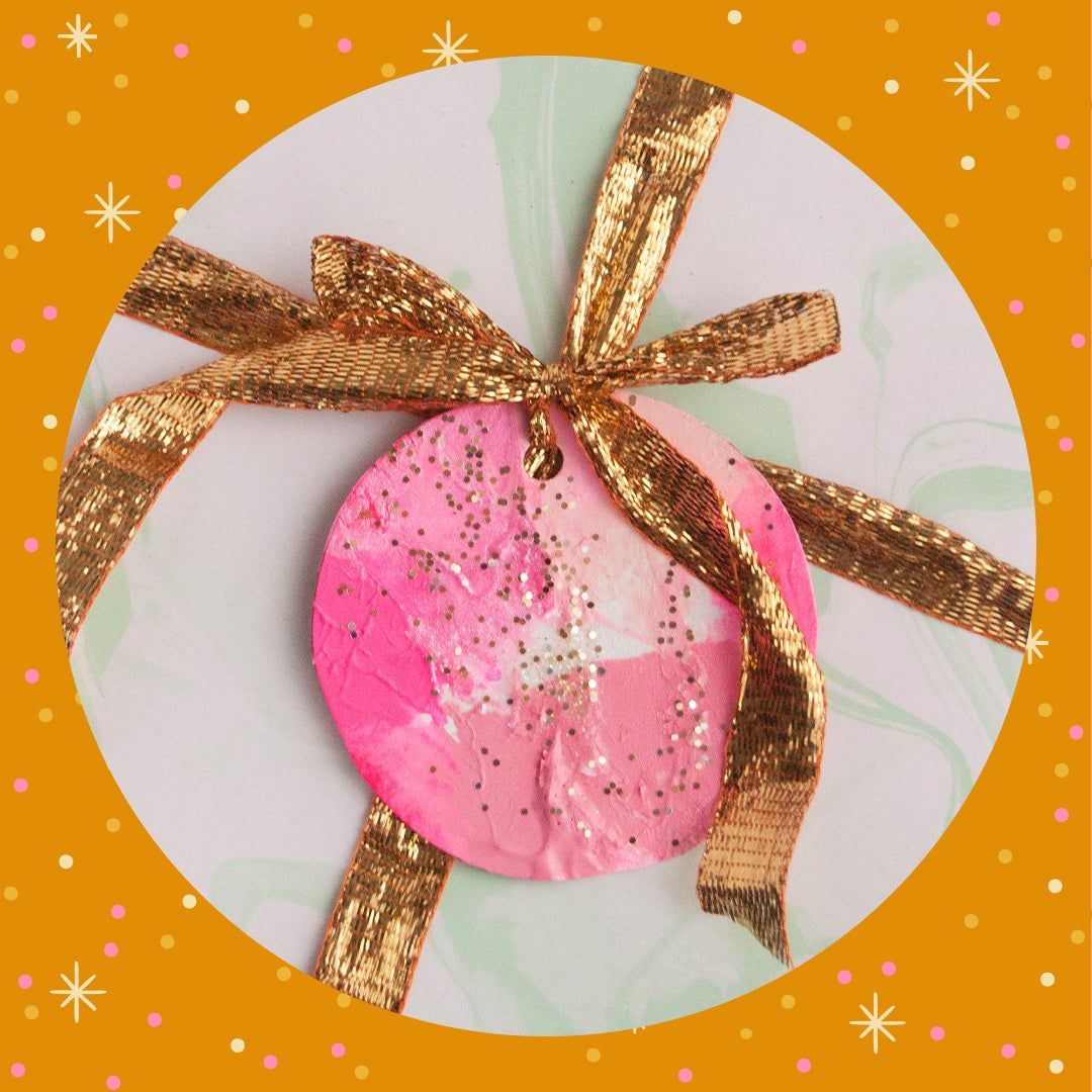 pink painted gift tag with a gold bow