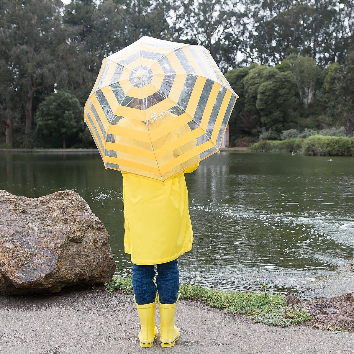 Kid in rain gear with an umbrella