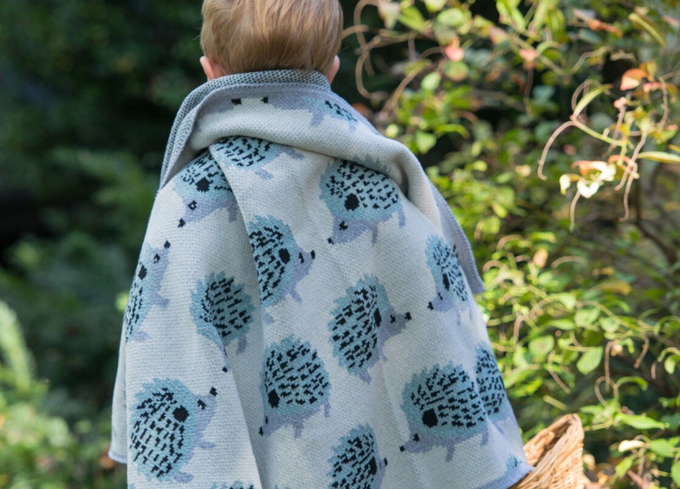 Little boy wearing porcupine blanket over his shoulders