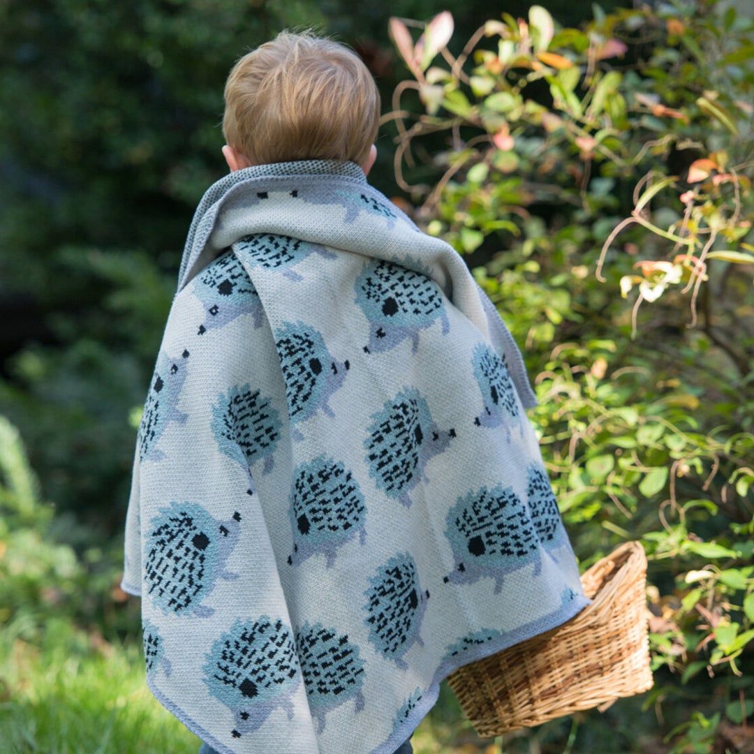 Little boy wearing porcupine blanket over his shoulders