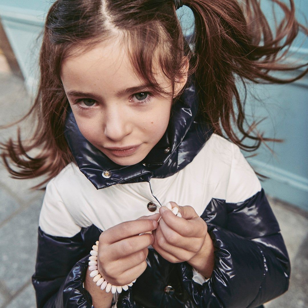 a girl wearing a navy and white puffer coat