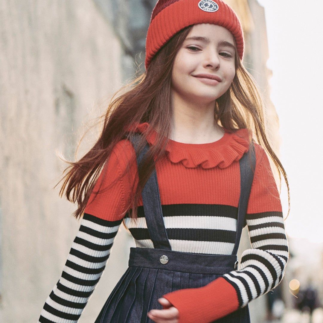 A girl wearing a striped sweater and winter hat