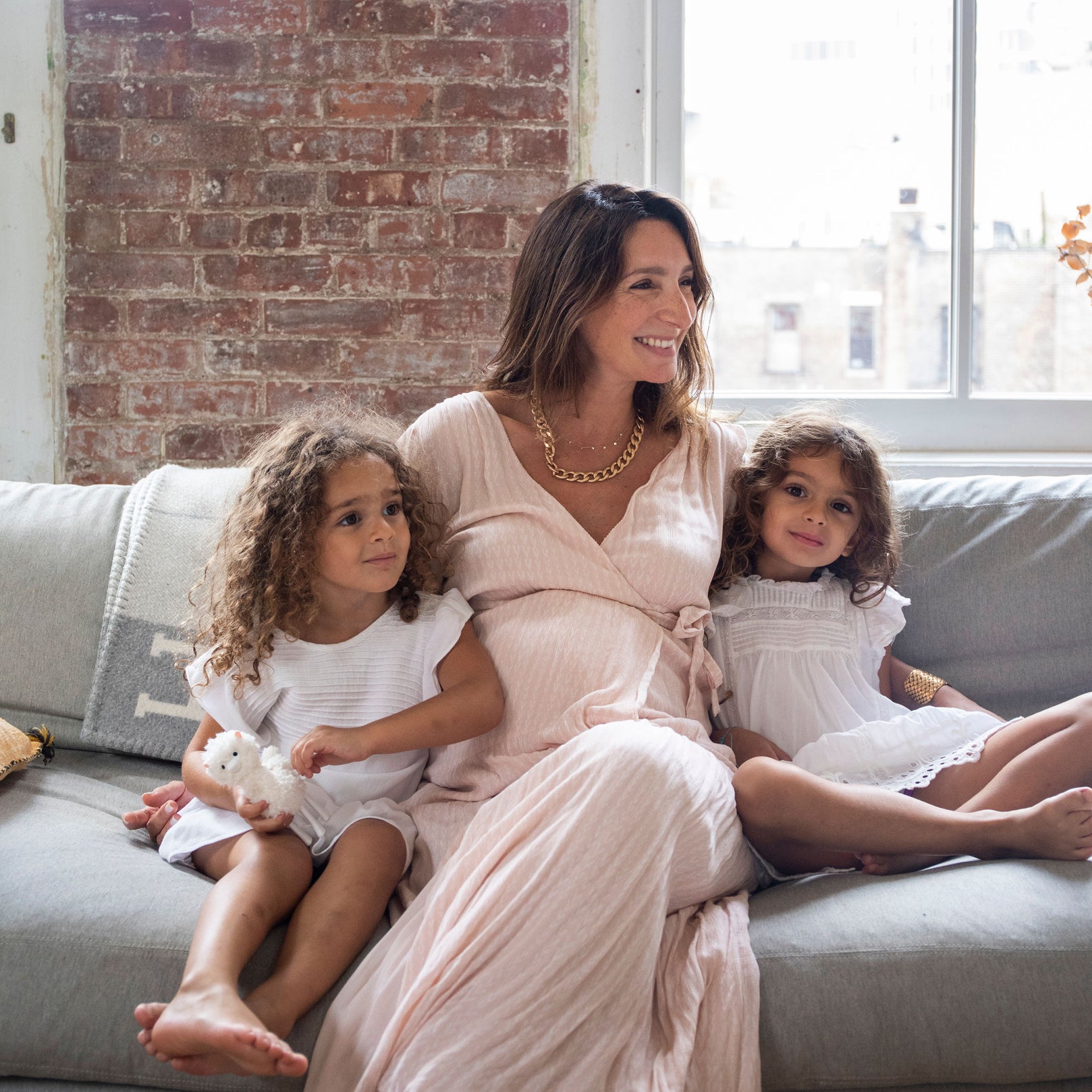 Julie Bourgeois and her two toddler daughters in light-colored dresses