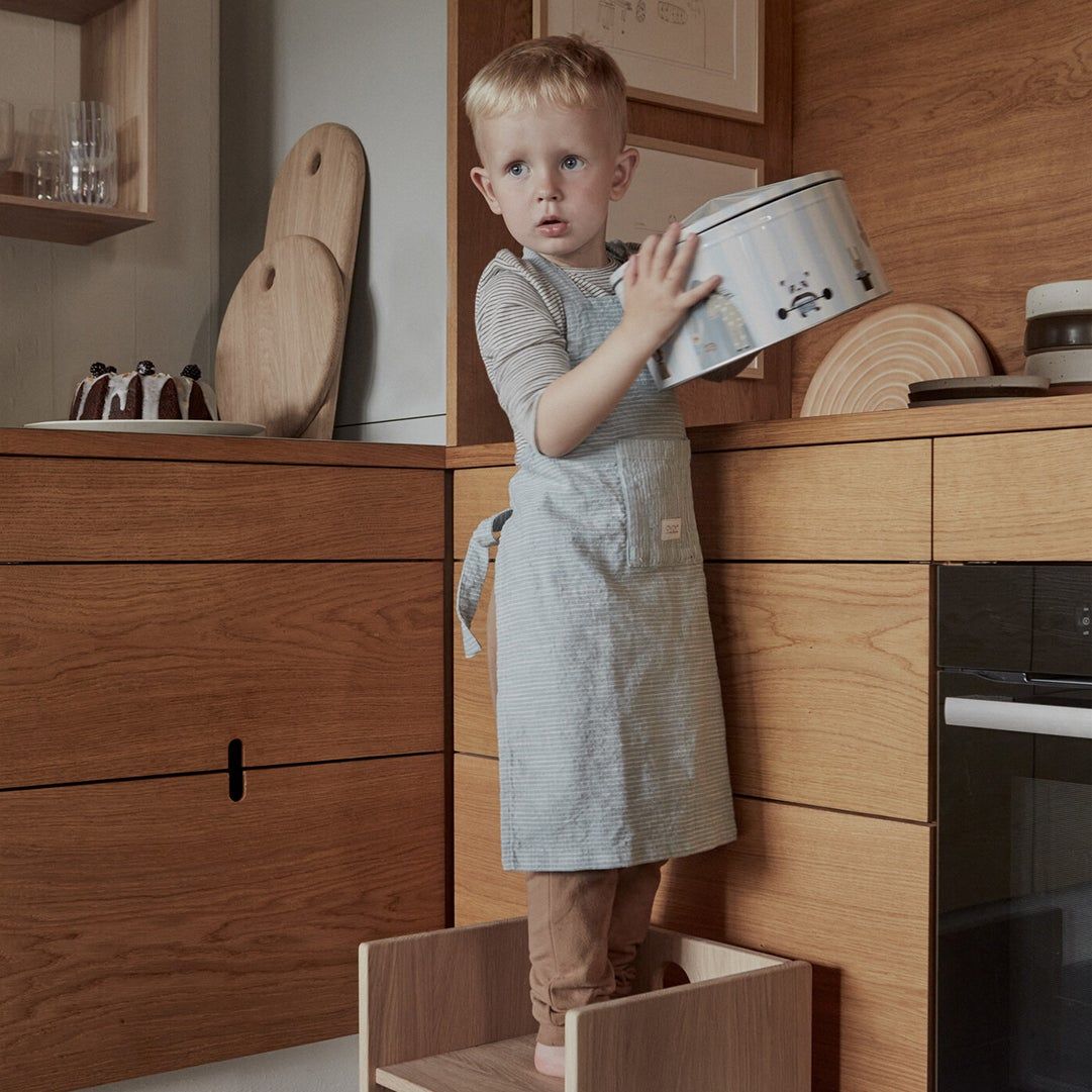 child in the kitchen with a Montessori toddler tower 