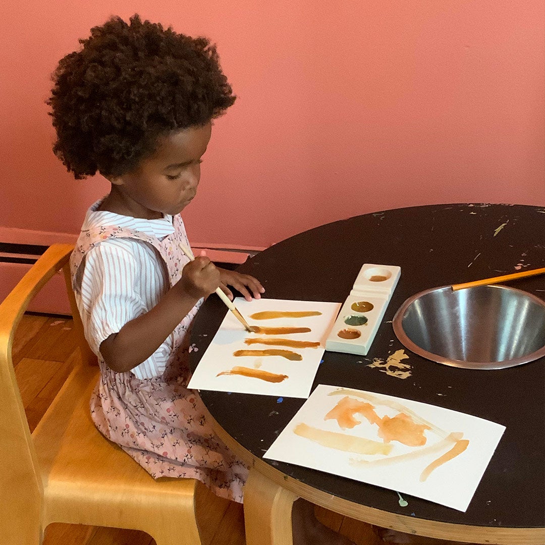 Lezi's daughters looking at leaves outside (left) and watercolor painting in their house (right)