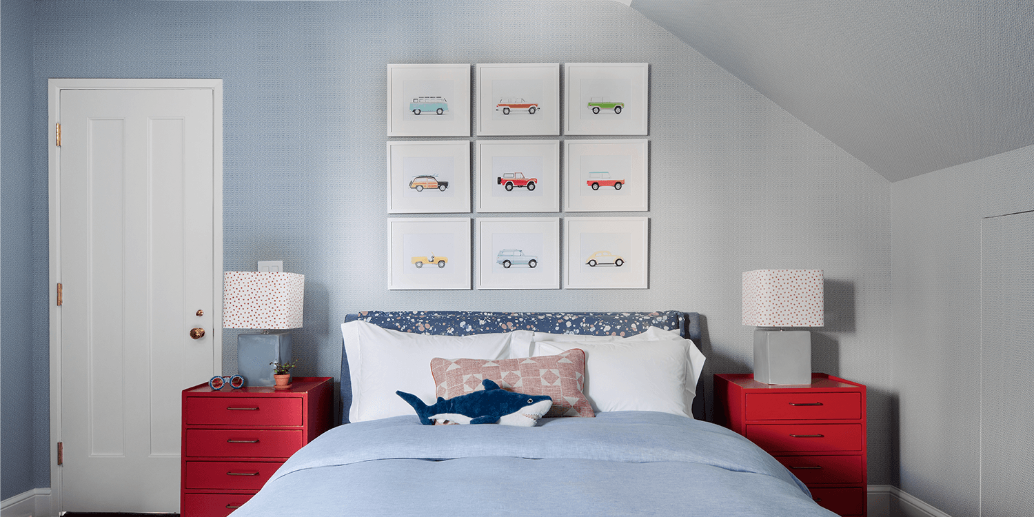 child's room with whale pillow and car art on the wall