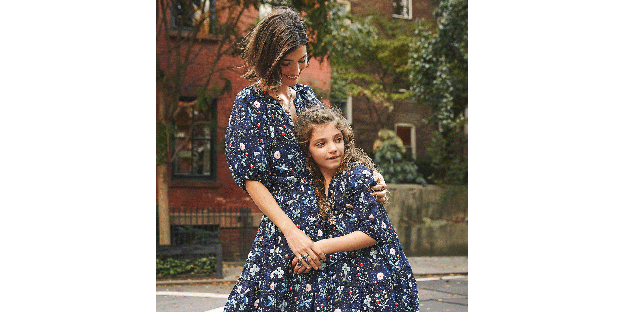 Maria and her daughter, Luna, standing outside in matching dresses
