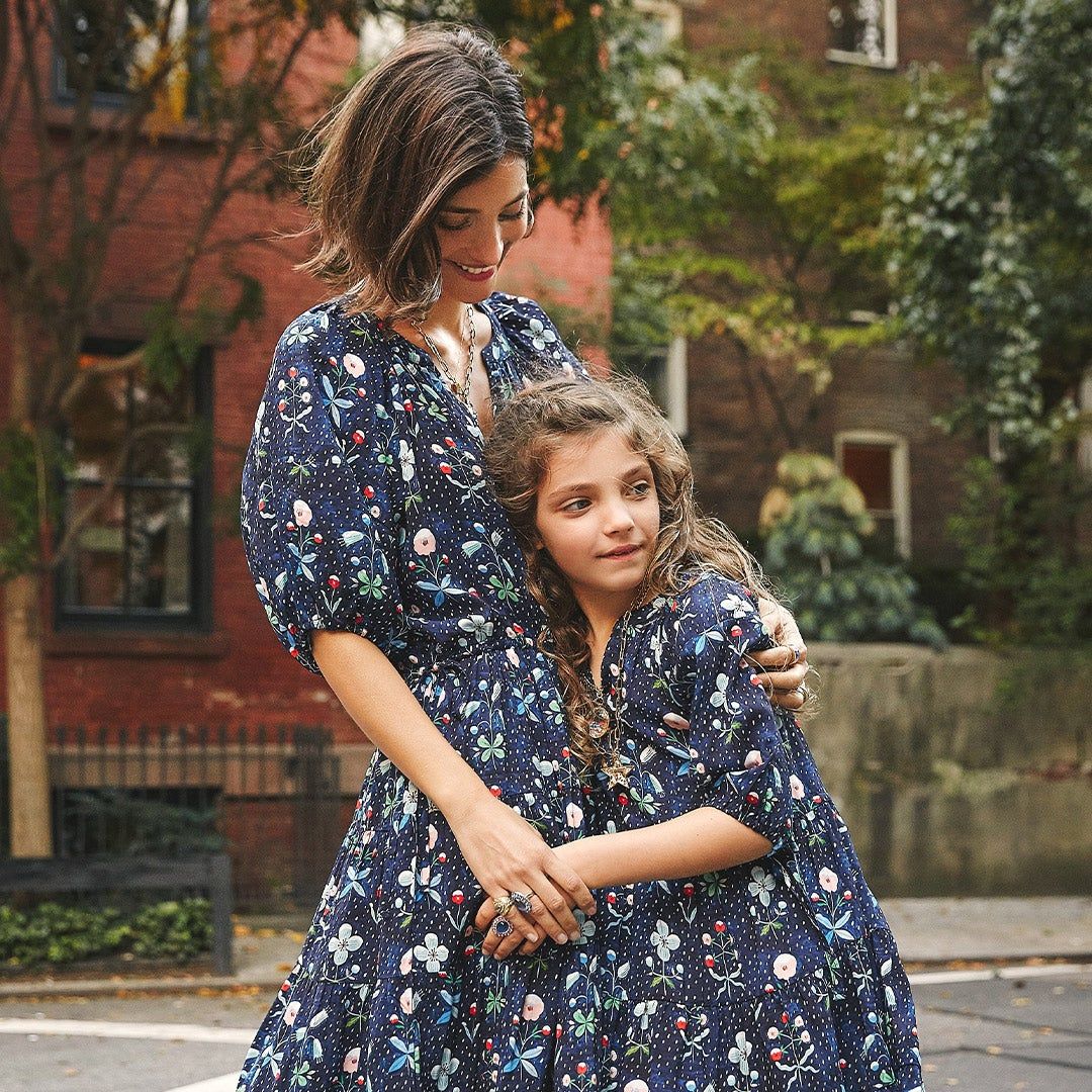 Maria and her daughter, Luna, standing outside in matching dresses