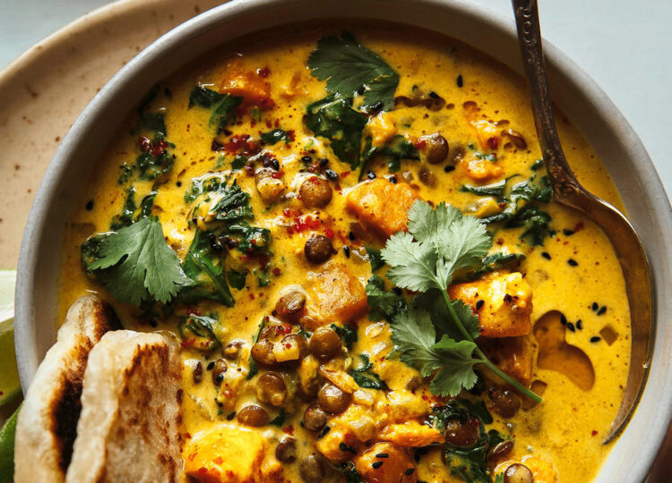 bowl of ginger sweet potato coconut milk stew with cilantro and naan