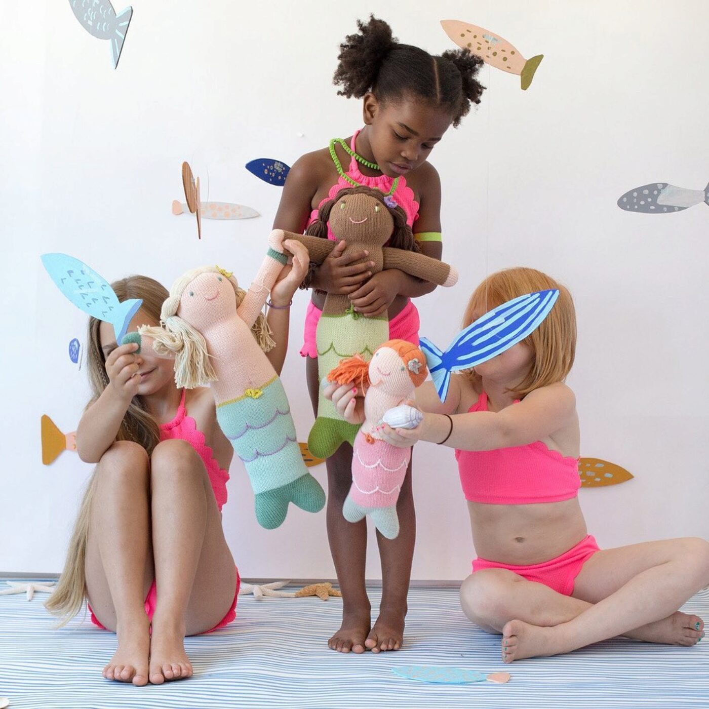 three girls with mermaid dolls in similar skin tones