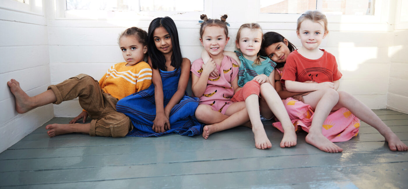 a group of kids sitting on the floor playing 