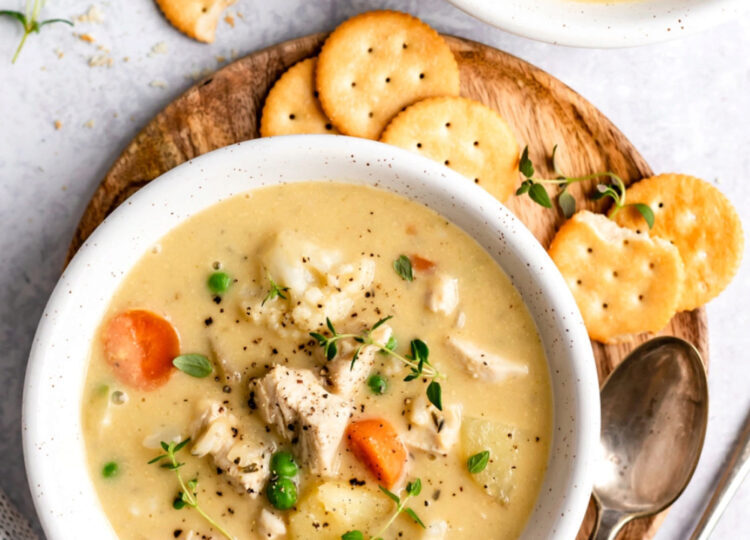 bowl of chicken pot pie soup next to Ritz crackers and a spoon