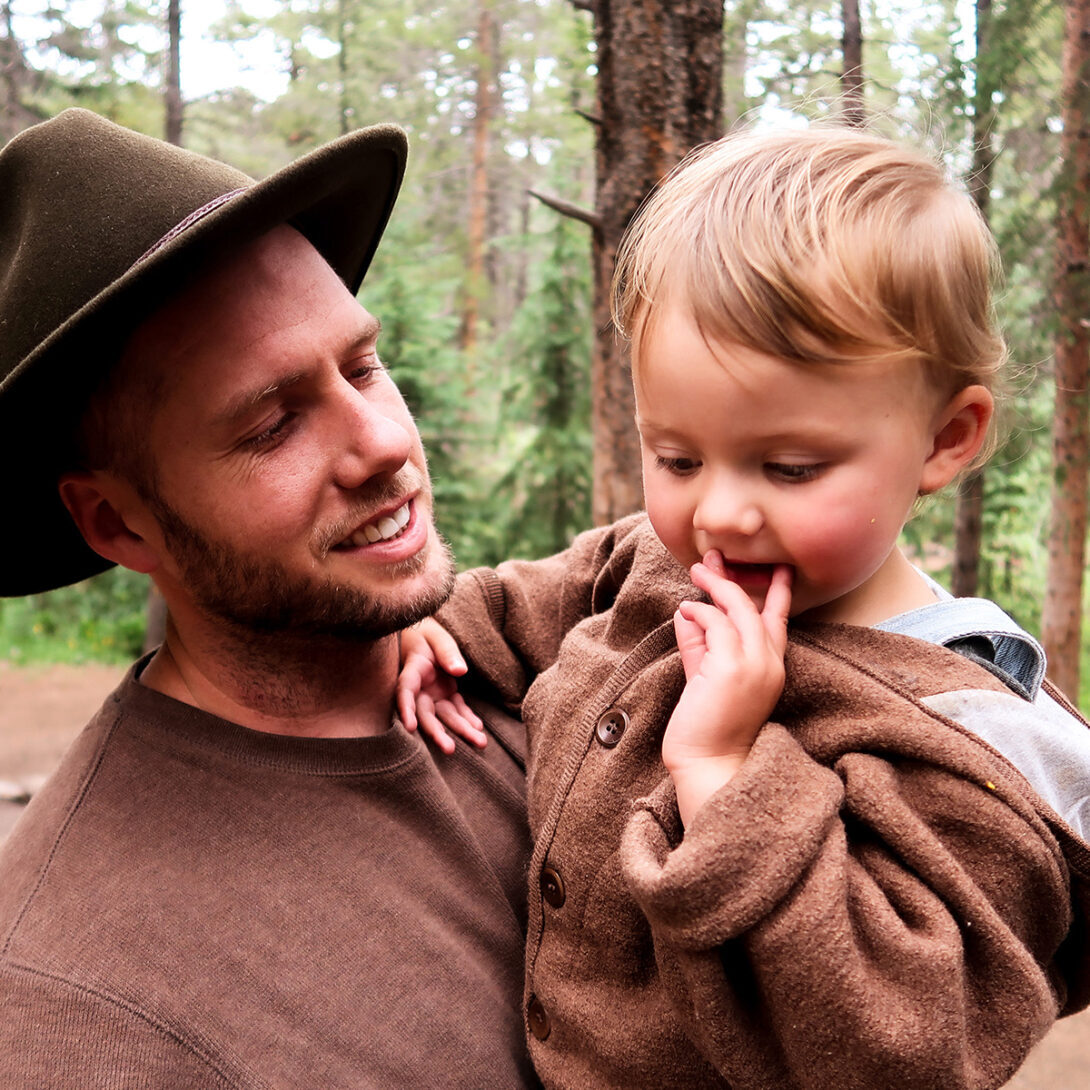 Matthew Durt holding daughter Uma, the Durt Family standing in front of a lake