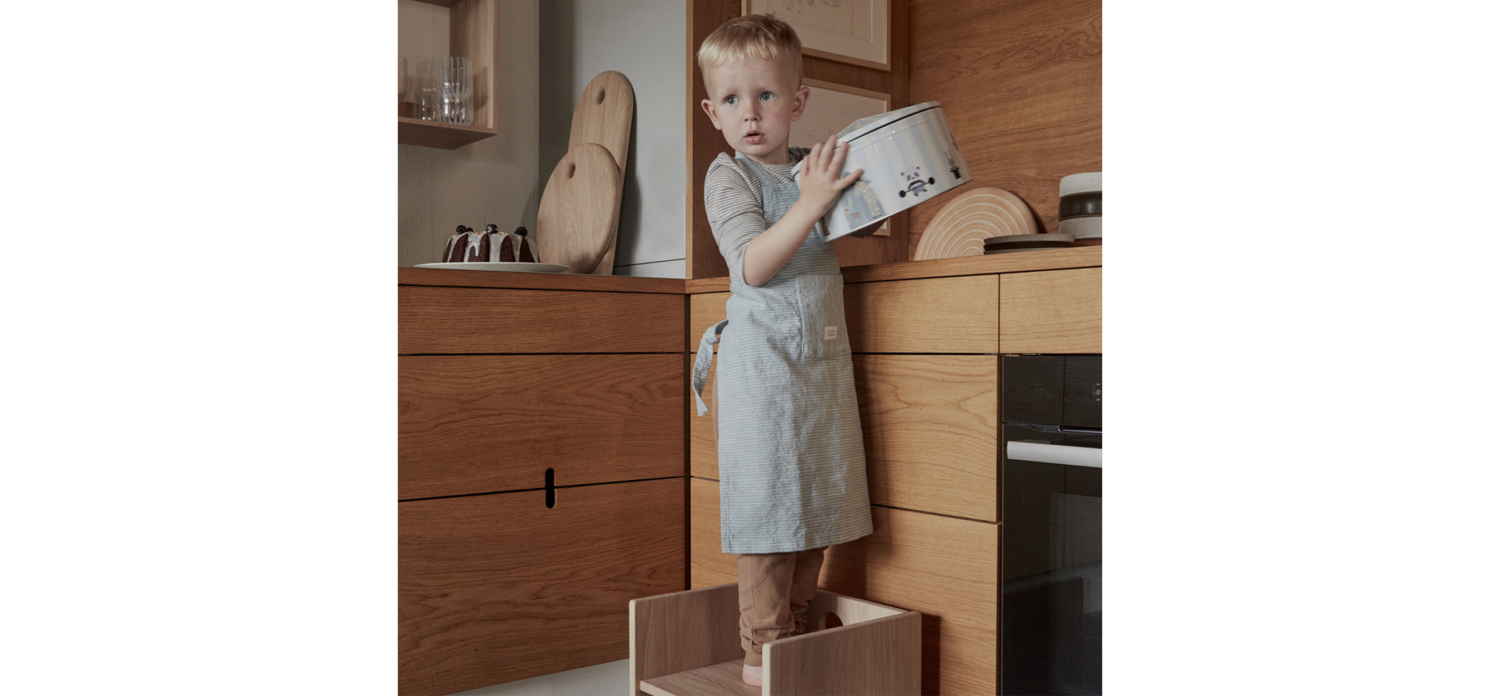 child in the kitchen with a Montessori toddler tower