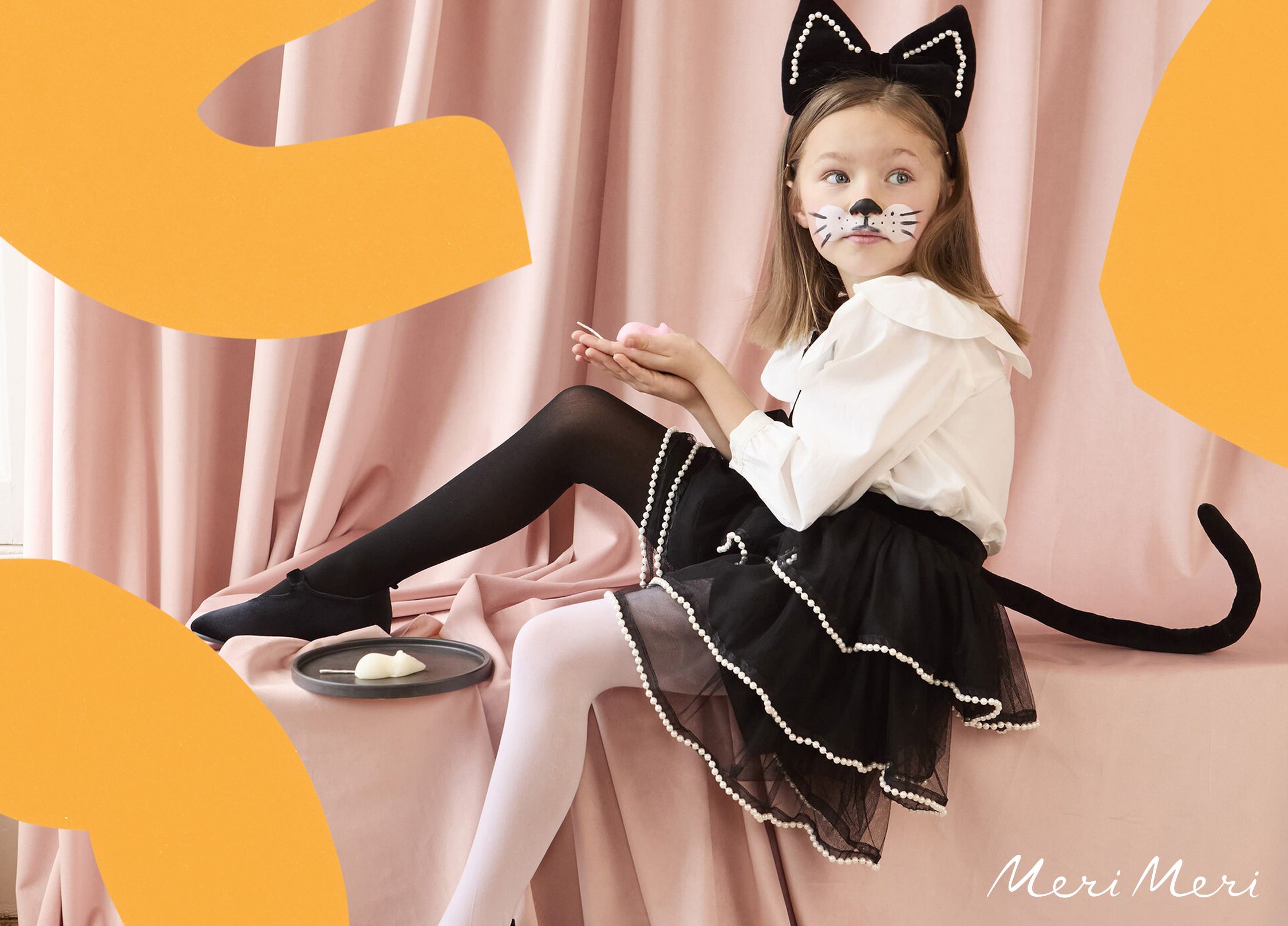 A young child in a fancy black cat costume.