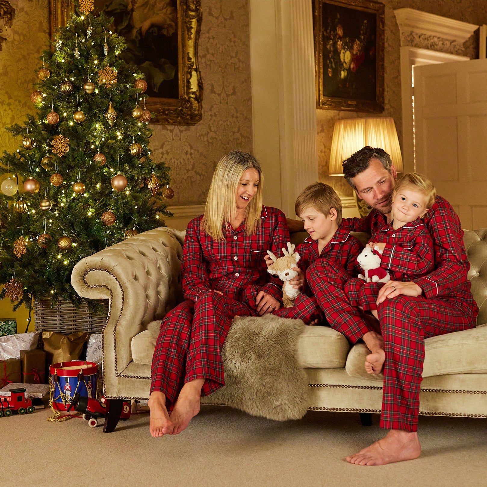family around Christmas tree in Trotters red tartan pajamas