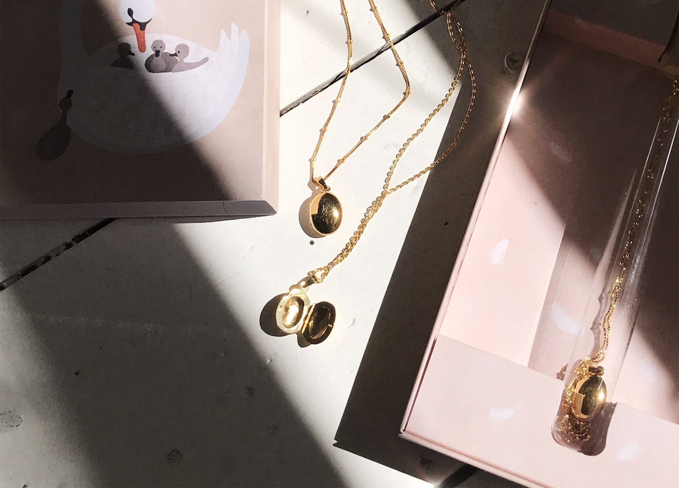 A gold necklace with a locker engraved with a child's initials.