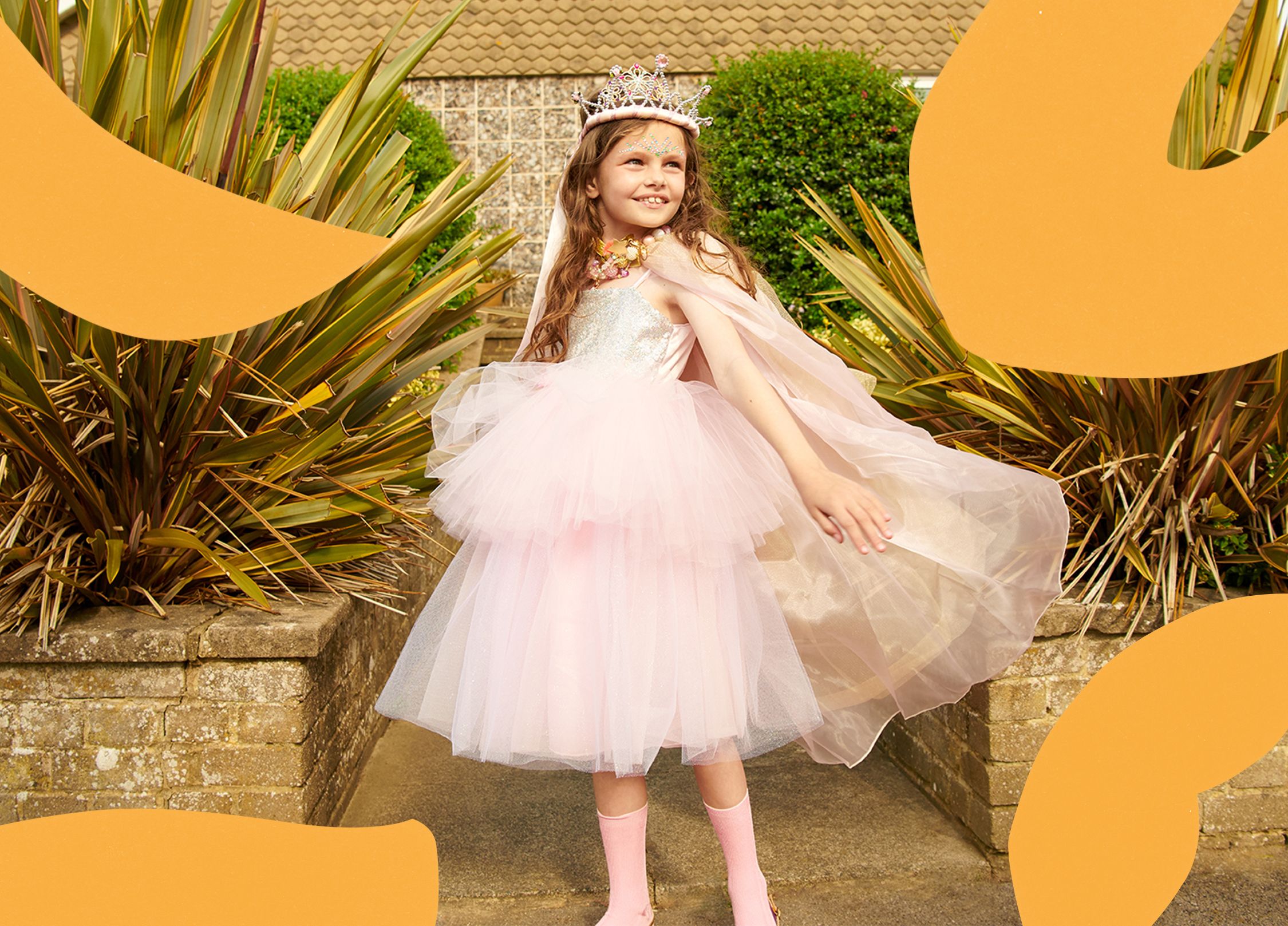 A young girl in a sparkly pink princess dress and crown.