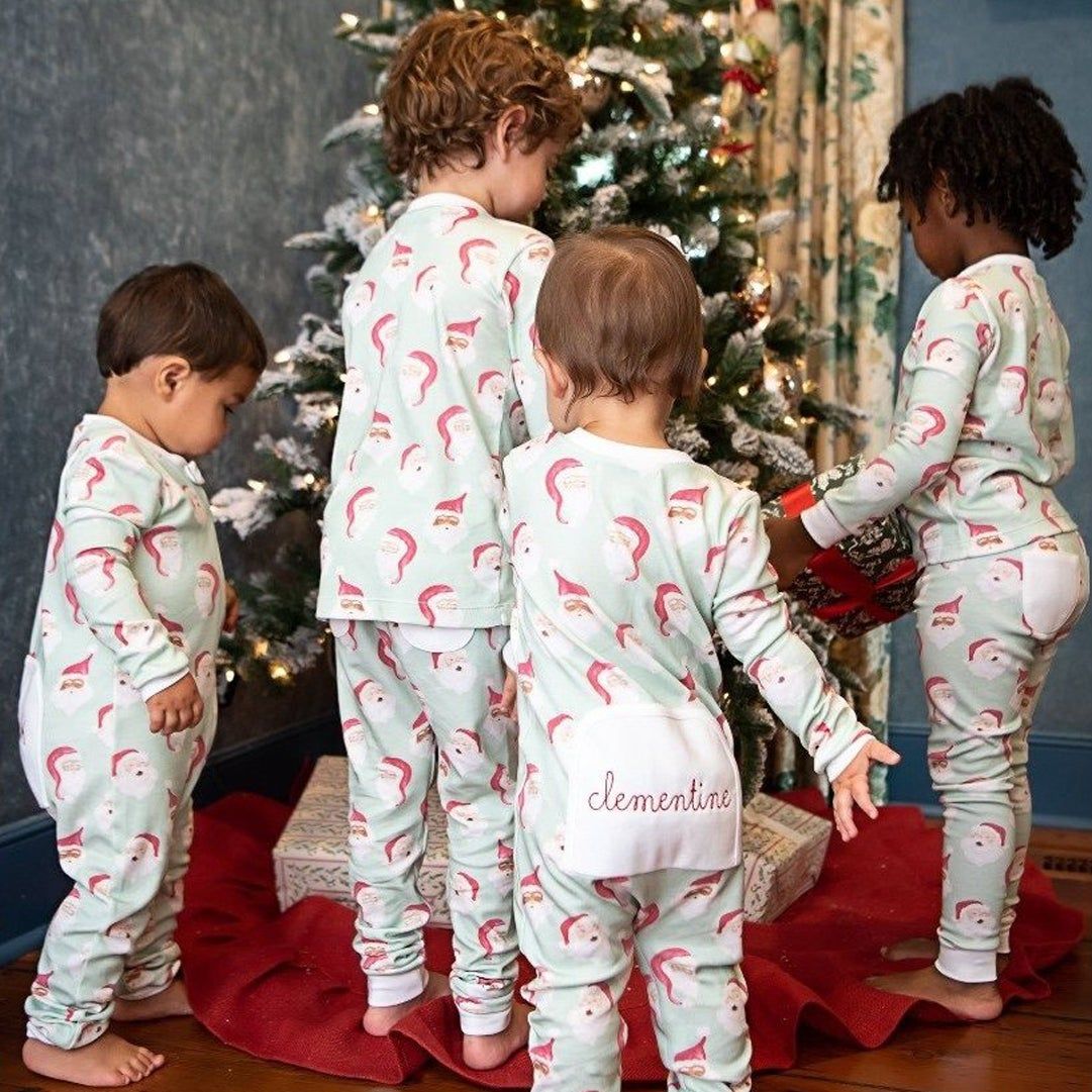 babies in monogrammed Christmas pajamas in front of a tree