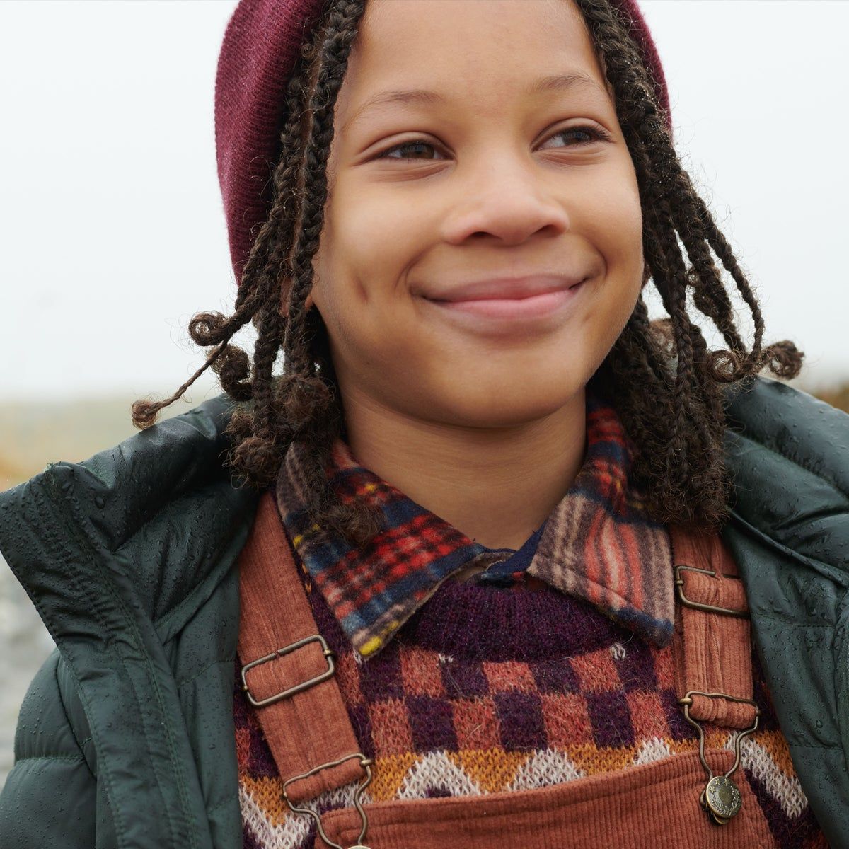 photo of a boy outside with overalls and winter gear