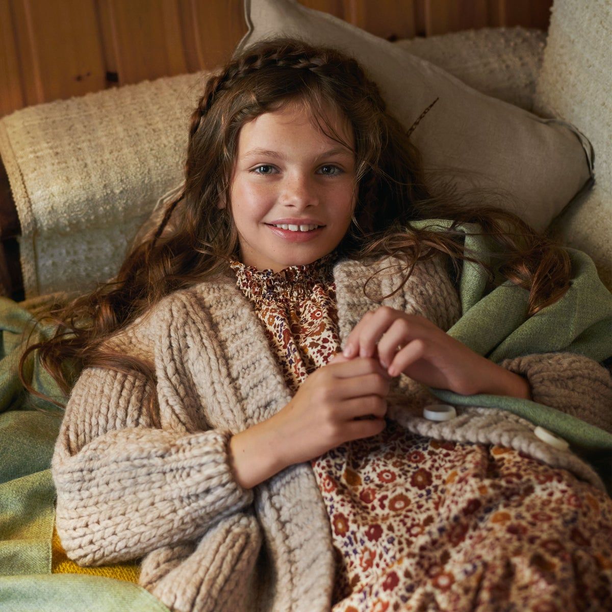 girl laying on a couch with a cozy warm sweater 