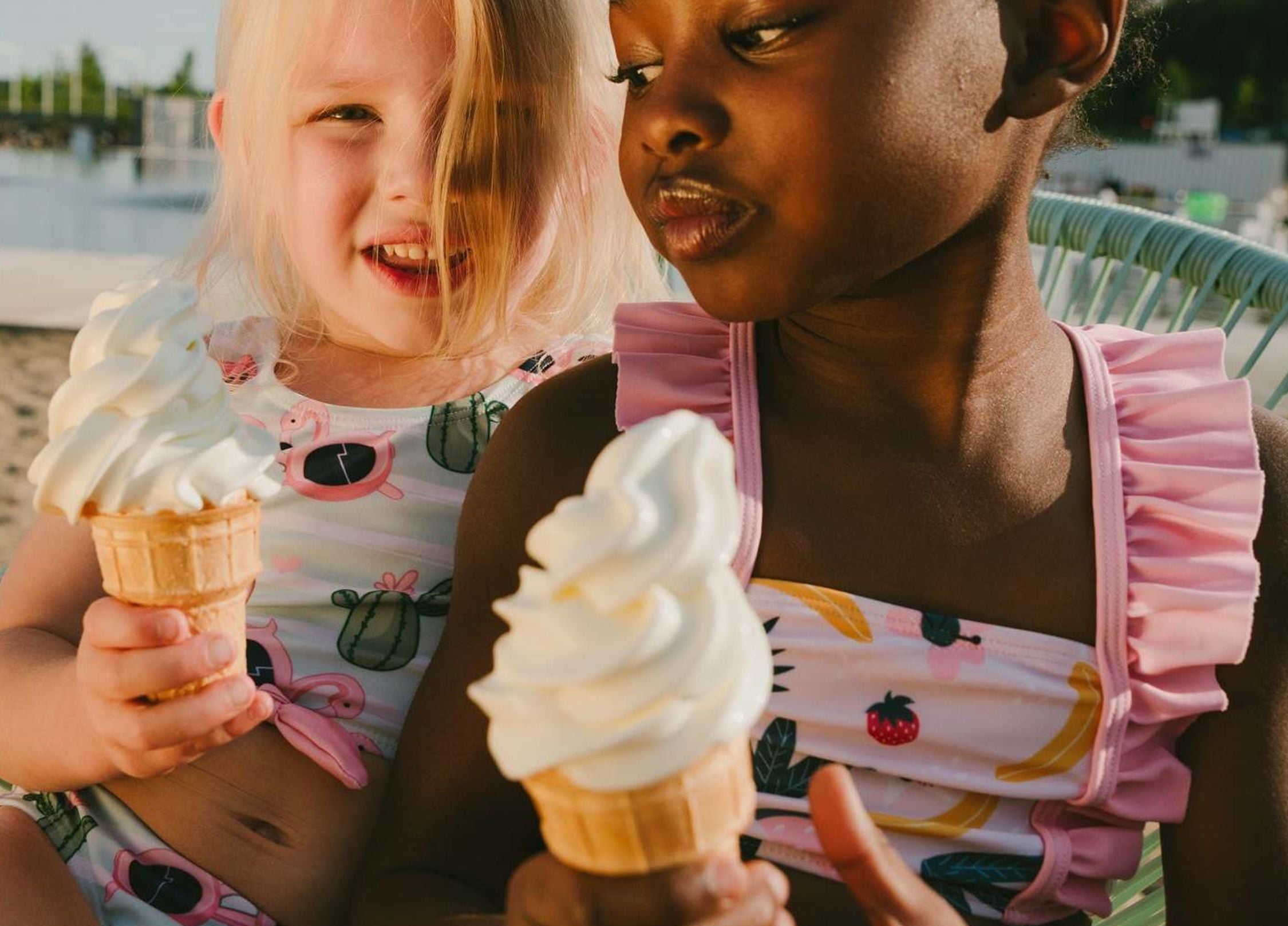 A child and baby in fruit-themed swimsuits.