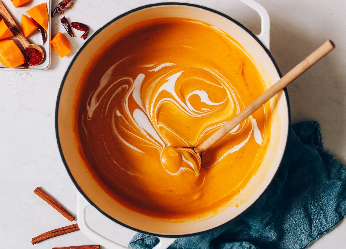 bowl of butternut squash soup in a pot next to a washcloth